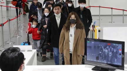 Des passagers&nbsp;en provenance de Wuhan portant des masques à leur arrivée à l'aéroport d'Osaka, au Japon, le 21 janvier 2020.&nbsp; (KEN SATOMI / YOMIURI)