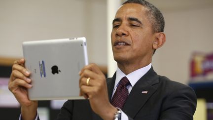 Le pr&eacute;sident am&eacute;ricain, Barack Obama, utilise un iPad lors d'une visite dans une &eacute;cole du Maryland (Etats-Unis), le 4 f&eacute;vrier 2014.&nbsp; (KEVIN LAMARQUE / REUTERS)