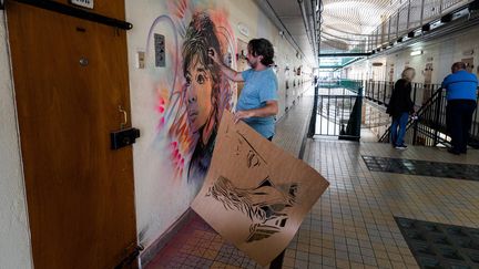 Sur un mur de la prison de Fresnes (Val-de-Marne), l'artiste C215 fait un portrait au pochoir de Juliette Greco (3 juillet 2020) (JOEL SAGET / AFP)