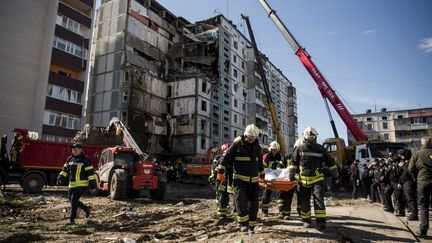 Des secouristes portent un corps retrouvé dans les décombres d'un immeuble touché par un missile russe à Ouman (Ukraine), le 28 avril 2023. (MAXYM MARUSENKO / NURPHOTO / AFP)