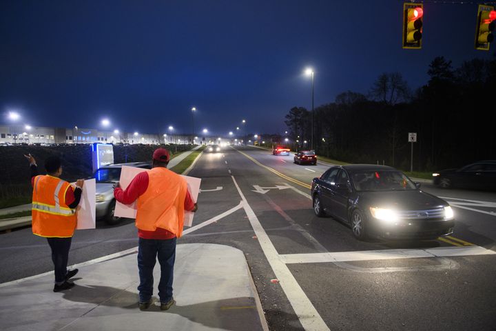 Des militants syndicaux se postent devant des voitures à une intersection à la sortie de l'entrepôt Amazon de Bessemer (Alabama), le 27 mars 2021. (PATRICK T. FALLON / AFP)