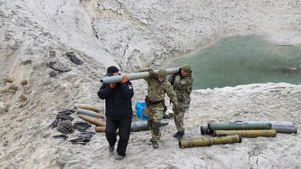 Des militaires portent un obus alors qu'ils travaillent à l'élimination des munitions collectées&nbsp;laissés par l'armée russe, région de Kiev le 20 avril 2022. (ANATOLII SIRYK / AVALON / MAXPPP)