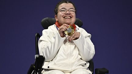 La joie d'Aurélie Aubert, médaillée d'or à la boccia, en catégorie BC1, sur le podium. La Tricolore a offert à son pays sa première victoire olympique dans cette discipline, introduite aux Jeux paralympiques de Los Angeles en 1984. (JULIEN DE ROSA / AFP)