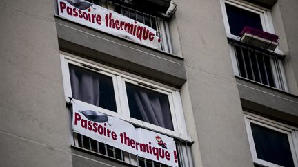 Une banderole accrochee a une fenetre denonce un probleme d isolation thermique dans un logement HLM de la ville de Paris, en 2018 (VINCENT ISORE / MAXPPP)