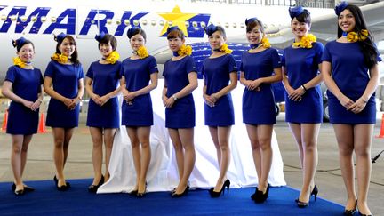 Des h&ocirc;tesses de l'air de la compagnie Skymark posent &agrave; l'a&eacute;roport de Tokyo (Japon), le 7 mars 2014.&nbsp; (KOTARO NUMATA / YOMIURI / AFP)