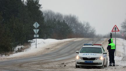 La police routière russe est présente sur le bord de la route à l'extérieur du village de Yablonovo, près du site de l'accident de l'avion de transport militaire russe IL-76 dans la région de Belgorod, le 24 janvier 2024. (STRINGER / AFP)