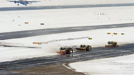 Ballet de chasse-neige à l'aéroport de Heathrow en Grande-Bretagne, submergée par la neige... (AFP - Carl de Souza)