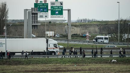 Un poids lourd entouré de migrants, le 3 décembre 2015, autour de Calais (Pas-de-Calais).&nbsp; (PHILIPPE HUGUEN / AFP)