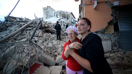 Des habitants sous le choc dans le village d'Amatrice.&nbsp; (FILIPPO MONTEFORTE / AFP)