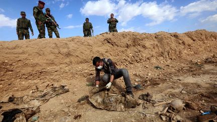 Un Irakien inspecte&nbsp;un charnier découvert à Sinuni, où des membres&nbsp;de la minorité yézidie ont été tués par des jihadistes de l'EI, le 3 février 2015.&nbsp; (SAFIN HAMED / AFP)