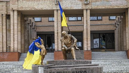 Le drapeau ukrainien accroché à une statue dans le centre de la Balakliia, le 10 septembre 2022, dans la région de Kharkiv, après la contre-offensive victorieuse de l'armée ukrainienne. (JUAN BARRETO / AFP)