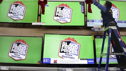 Un vendeur ajuste un ruban sur une t&eacute;l&eacute;vision annon&ccedil;ant le Black Friday, &agrave; Los Angeles (Etats-Unis), le 24 novembre 2014. (JONATHAN ALCORN / REUTERS)