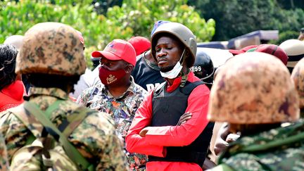 Bobi Wine, de son vrai nom&nbsp;Robert Kyagulanyi, est bloqué par des policiers, puis arrêté à Kalangala en Ouganda le 30 décembre 2020. Désormais, il porte un gilet pare-balles et un casque lors de sa tournée électorale. (Reuters/Stringer)