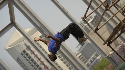 Un Yamakasi fait une performance sur le site de l'ambassade de France en Chine, mai 2010
 (PETER PARKS / AFP)