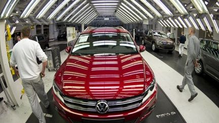 Des ouvriers inspectent une Volkswagen, dans l'usine de Wolfsburg, le 7 mai 2012 . (AFP/ODD ANDERSEN)