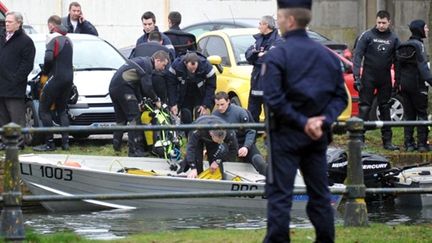 Les sapeurs pompiers et enquêteurs autour du canal de la Deûle, à Lille, le 25 février 2011 (AFP/PHILIPPE HUGUEN)