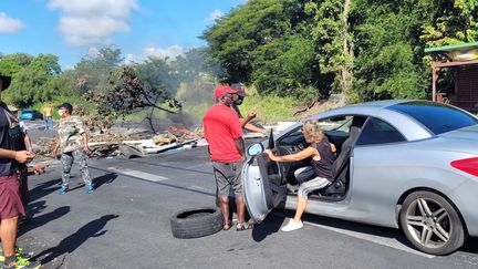 Des manifestants laissent une infirmière traverser un barrage dressé au Gosier, en Guadeloupe, le 23 novembre 2021.&nbsp; (FABIEN MAGNENOU / FRANCEINFO)