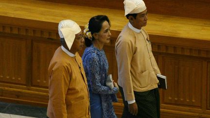 Le président Htin Kyaw (à gauche), premier dirigeant birman à n'avoir aucun lien avec l'armée depuis plus d'un demi-siècle, a prêté serment mercredi 30 mars 2016 devant le Parlement dominé par les élus de la Ligue nationale pour la démocratie (LND) de la lauréate du prix Nobel de la paix Aung San Suu Kyi (au centre). La «dame de Rangoun», dont le parti a remporté une victoire écrasante lors des législatives de novembre, a confié à ce proche la charge de diriger le pays, étant elle-même tenue à l'écart de la fonction suprême par la Constitution rédigée par l'ancienne junte militaire.  (ROMEO GACAD / AFP)