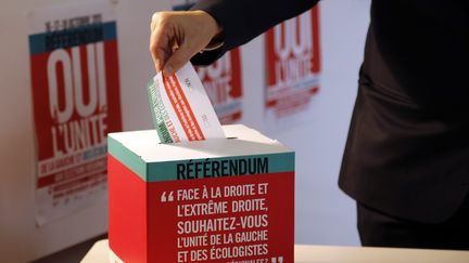 Un homme met son bulletin lors du r&eacute;f&eacute;rendum sur l'unit&eacute; de la gauche organis&eacute; par le PS &agrave; Paris, le 16 octobre 2015. (FRANCOIS GUILLOT / AFP)