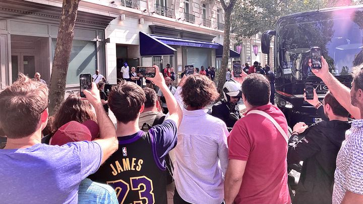 Des supporters prennent des photos au moment de la sortie de l'hôtel des stars de la NBA, à Paris, le 2 août 2024. (FRANCEINFO / BENOIT JOURDAIN)