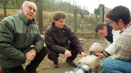 Le juge d'instruction du tribunal de Châteauroux, Jean Dematteis (au milieu), observe, le 14 janvier 2000 sur les voies de la gare de Chabenet, en compagnie de Rémy Julienne (à gauche), le mannequin qui doit servir pour la reconstitution du meurtre d'Isabel Peake. (MEHDI FEDOUACH / AFP)