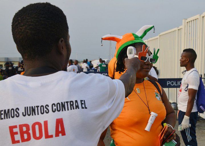 Un agent de santé vérifie la température du corps d'un supporter dans le cadre d'un dépistage Ebola pendant la Coupe d'Afrique des nations et avant le match Cameroun - Côte-d'Ivoire à Malabo le 28 janvier 2015 (AFP / ISSOUF SANOGO)