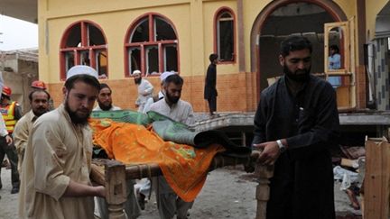 Des fidèles évacuent les décombres d'une mosquée à Akhurwall (Pakistan) après un attentat (05/11/2010) (AFP/A MAJEED)