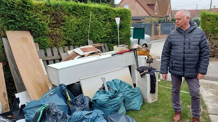 Un habitant sinistré devant sa maison avec son mobilier, un mois après l'inondation dans le Pas-de-Calais. (BENJAMIN ILLY / FRANCEINFO)