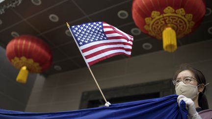 Une miliante brandit un drapeau américain devant le consulat chinois de Houston, aux Etats-Unis, le 24 juillet 2020.&nbsp; (MARK FELIX / AFP )