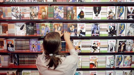 Une cliente devant le rayon mangas d'une librairie (2010).&nbsp; (MARTIN BUREAU / AFP)