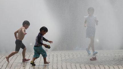 Des enfants jouent dans une fontaine à eau à Nagoya (Japon) durant une vague de chaleur, le 3 août 2019. (TOSHIKAZU SATO / YOMIURI)