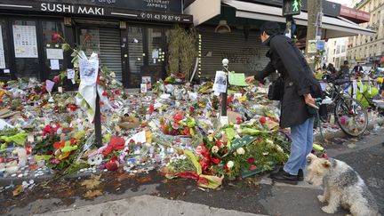 Les passants déposent des fleurs devant la Belle équipe, le 18 novembre 2016. (BERTRAND GUAY / AFP)