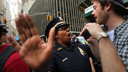 Une polici&egrave;re&nbsp;(G.) et un manifestant d'Occupy Wall Street se font face non loin de la Bourse de New York le 17 septembre 2012. (SPENCER PLATT / GETTY / AFP)