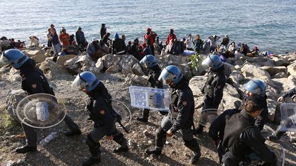 Des policiers italiens face à des migrants, le 30 septembre 2015 à la frontière franco-italienne. (VALERY HACHE / AFP)