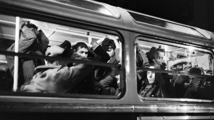 Des manifestants algériens les mains sur la tête dans un bus de la RATP réquisitionné par la police, le 17 octobre 1961. (AFP)