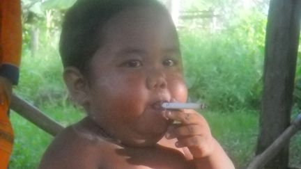 Le jeune Indonésien Aldi Rizal, alors âgé de deux ans, fume une cigarette dans un village de l'île de Sumatra, le 16 mai 2010. (AHMAD NAAFI / AFP)