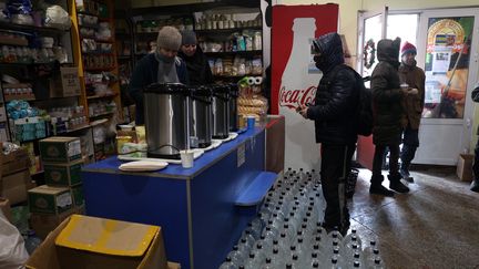 Des habitants de de Bakhmut, dans la région de Donetsk dans l'est de l'Ukraine, se rassemblent dans un "centre d'invincibilité" organisé par des bénévoles, le 17 janvier 2023. (ANATOLII STEPANOV / AFP)