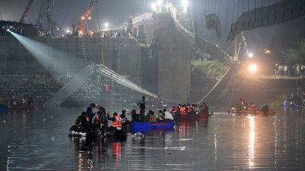 Des secouristes mènent des opérations de recherche après l'effondrement d'un pont sur la rivière Machchhu à Morbi (Inde)le 31 octobre 2022. (SAM PANTHAKY / AFP)