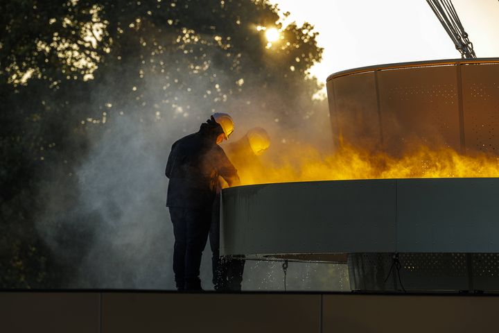 Deux techniciens interviennent sur la vasque olympique aux Tuileries, à Paris, le 28 juillet 2024. (STEPHANE ALLAMAN/SIPA / SIPA)