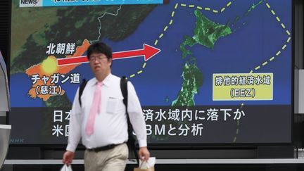 Un homme passe devant un écran modélisant le trajet d'un missile nord-coréen, le 29 juillet 2017 à Tokyo (Japon). (KUNIHIKO MIURA / YOMIURI)