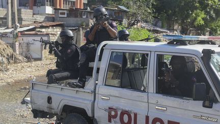 Des policiers patrouillant dans la zone lors d'un échange de coups de feu entre des gangs et la police à Port-au-Prince, en Haïti, le lundi 11 novembre 2024. (ODELYN JOSEPH / AP)