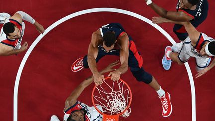 Le dunk de Rudy Gobert (au centre) face à Kevin Durant, lors de la finale des Jeux olympiques du tournoi de basket entre la France et les Etats-Unis, le 7 août 2021. (ARIS MESSINIS / AFP)