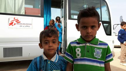 Deux enfants réfugiés du camp de Dibaga, au sud de Mossoul, devant le bus où&nbsp;Médecins sans frontières dispense un soutien psychologique.&nbsp; (MATHILDE LEMAIRE / RADIO FRANCE)