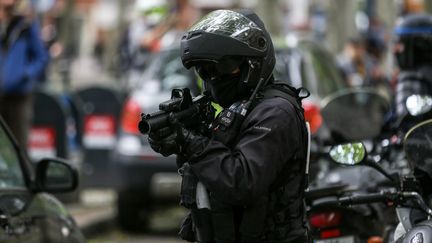 Un policier vise avec un lanceur de balle de défense, le 11 mai 2019 à Toulouse, lors d'une manifestation de "gilets jaunes". (FREDERIC SCHEIBER / HANS LUCAS / AFP)