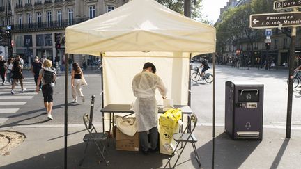 Un homme prépare des tests antigéniques sous une tente, à Paris, le 6 septembre 2021. (NICOLAS PORTNOI / HANS LUCAS / AFP)