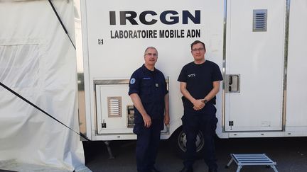 Le colonel François Heulard (à gauche) et&nbsp;&nbsp;Amaury Pussiau, chef d'escadron et expert en empreintes génétiques, devant leur laboratoire mobile, à Kiev (Ukraine), jeudi 12 mai 2022. (AGATHE MAHUET / RADIO FRANCE)