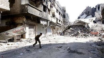 Combattant dans les ruines du camp palestinien de Yarmouk, au sud de Damas. (ANWAR AMRO / AFP)