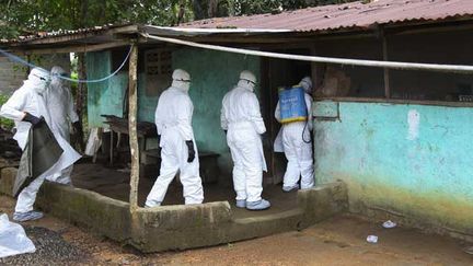 &nbsp; (Une équipe médicale entre dans une maison pour récupérer une victime du virus Ebola au Libéria © Maxppp)