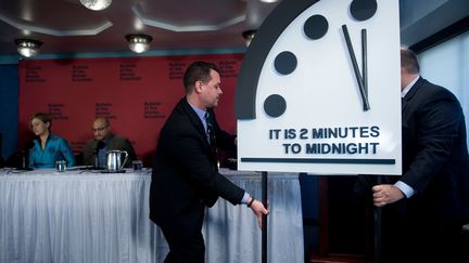 Des membres du "Bulletin of Atomic Scientists" présentent l'aiguille de l'horloge&nbsp;de l'apocalypse, qui symbolise l'imminence d'un cataclysme planétaire, à Washington (Etats-Unis), jeudi 25 janvier.&nbsp; (BRENDAN SMIALOWSKI / AFP)