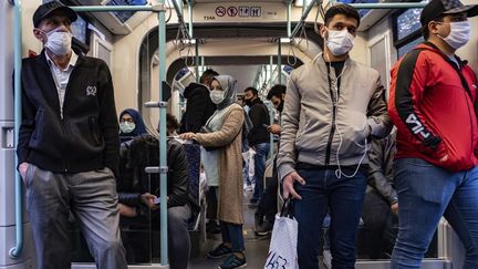 Des passagers portent des masques ou des visières contre le Covid-19 dans le métro d'Istanbul, en Turquie, le 27 mai 2020.&nbsp; (YASIN AKGUL / AFP)